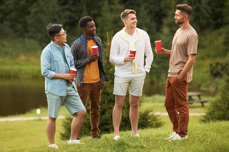 Group of men chatting outdoors holding red cups