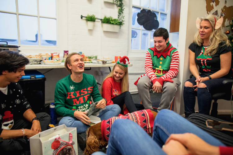 group of coworkers sharing secret santa questions and gifts
