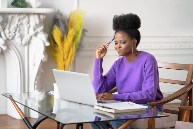 woman thinking about something in front of a laptop