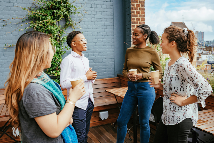 group of diverse people chatting outside over coffee