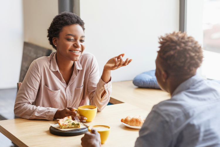 two people chatting over a coffee and some pastries