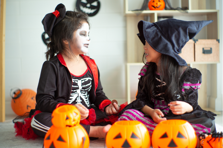 smiling girls wearing halloween costumes sitting