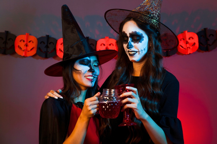 women with drinks dressed as witches