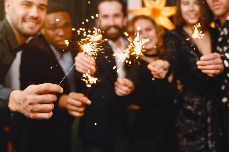 people holding sparklers and smiling