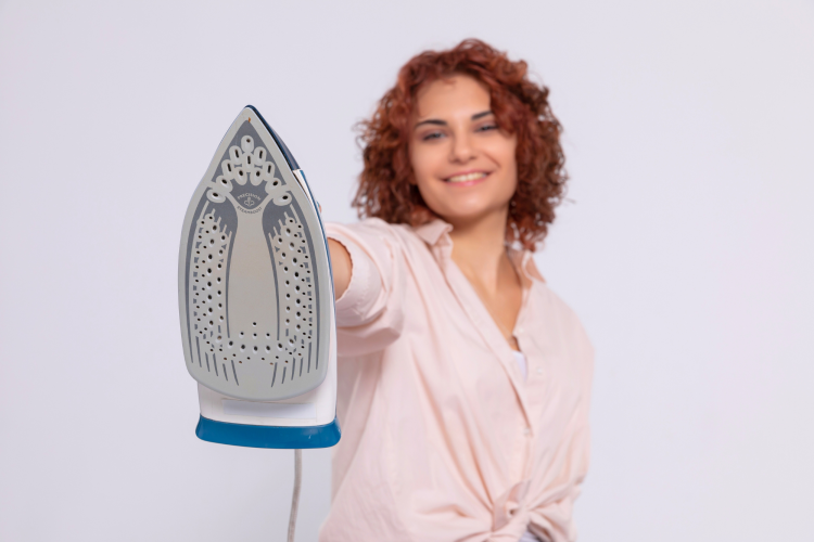 a woman wih an iron smiling