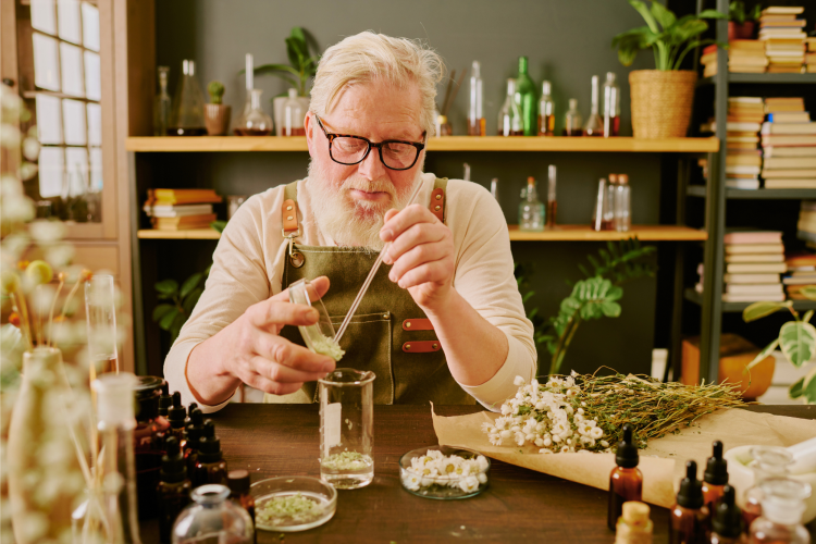 man mixing perfumes with flowers