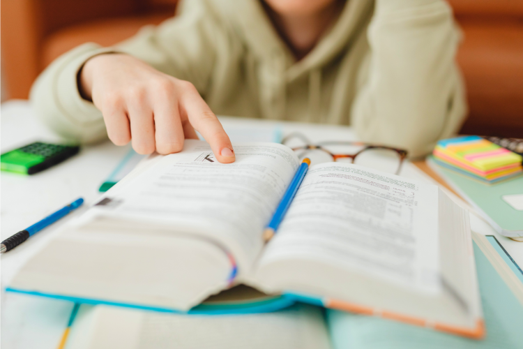 person studying with a large textbook