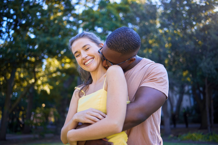 man kissing a woman's neck