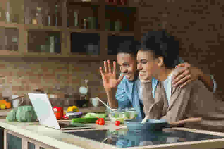 young couple waving during a virtual dinner party