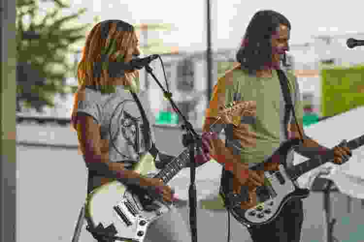 man and women on stage with guitar and singing