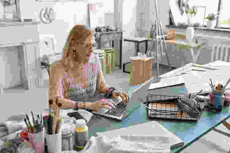 woman with computer in painting studio