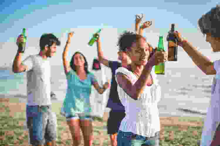 group drinking beer on the beach for 40th birthday party idea