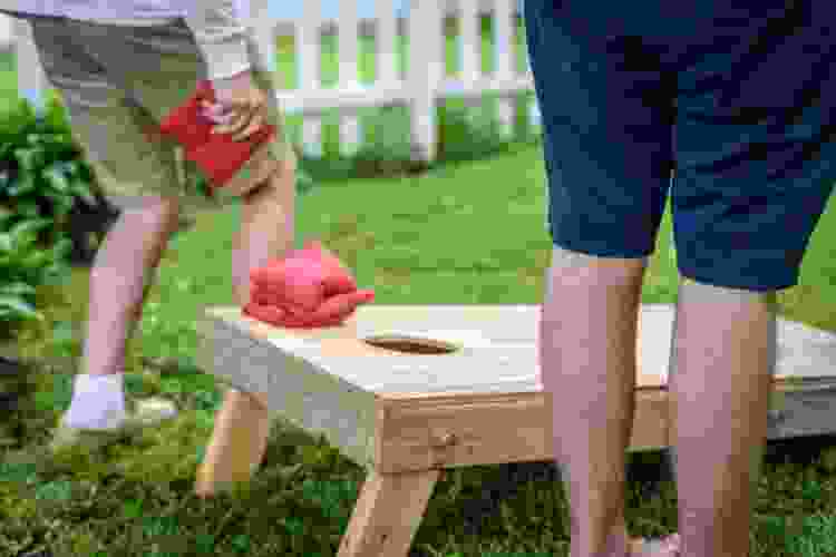 tossing beanbag in cornhole game