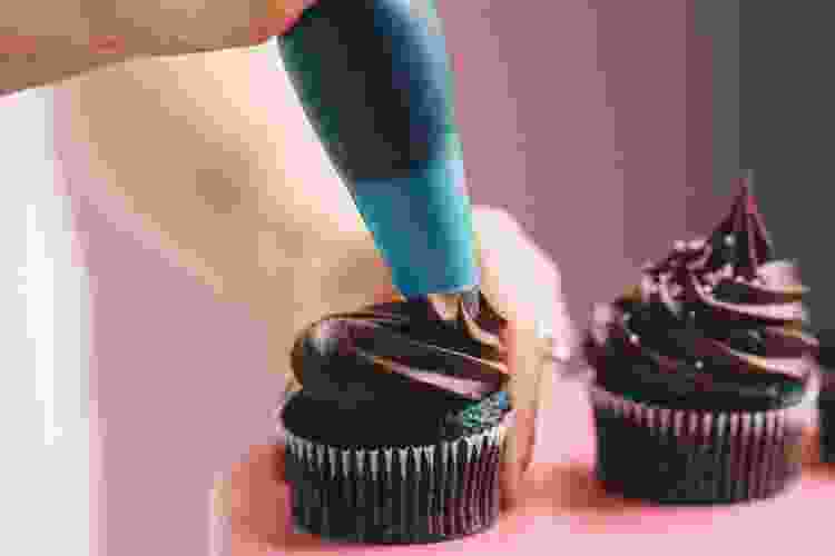 hand frosting chocolate cupcakes