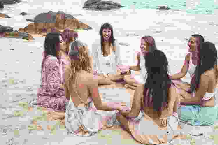 group of women on beach holding hands in circle