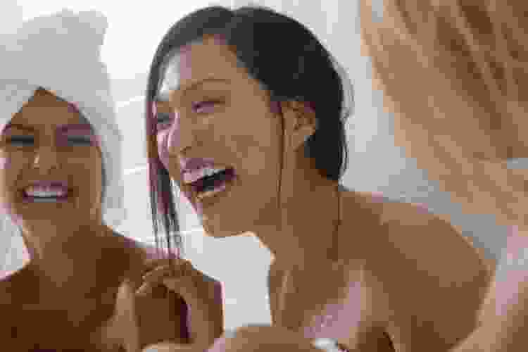 three women laughing in towels at spa