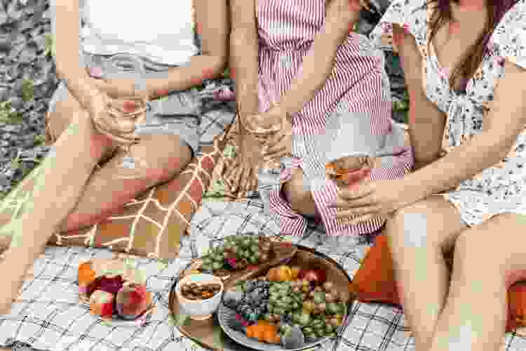 drinking wine on picnic blanket with fruit 