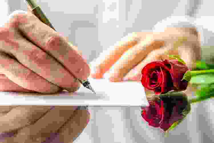 hand writing love letter on paper with pen