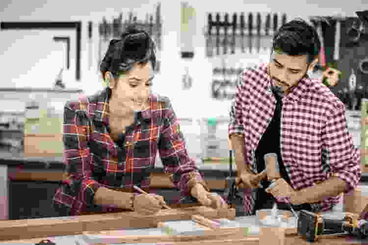 couple in woodshop building with wood