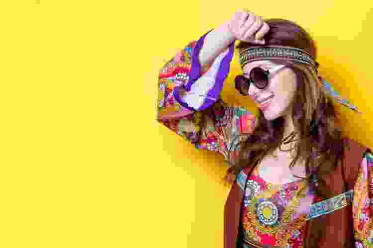 person dressed in hippie pattern dress with sunglasses and headband