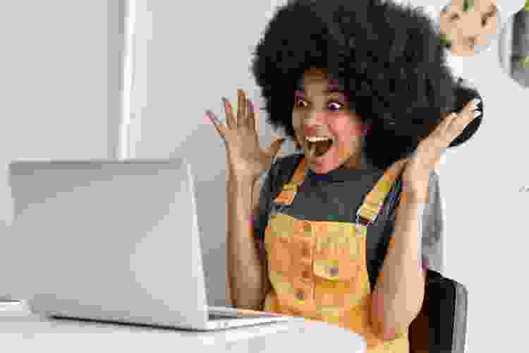 woman excited expression during video call on laptop