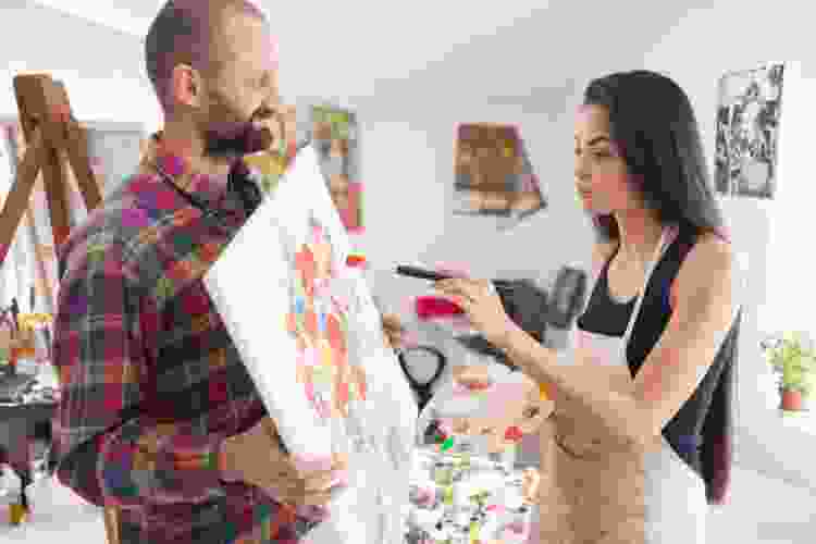 couple holding painting of flower bouquet