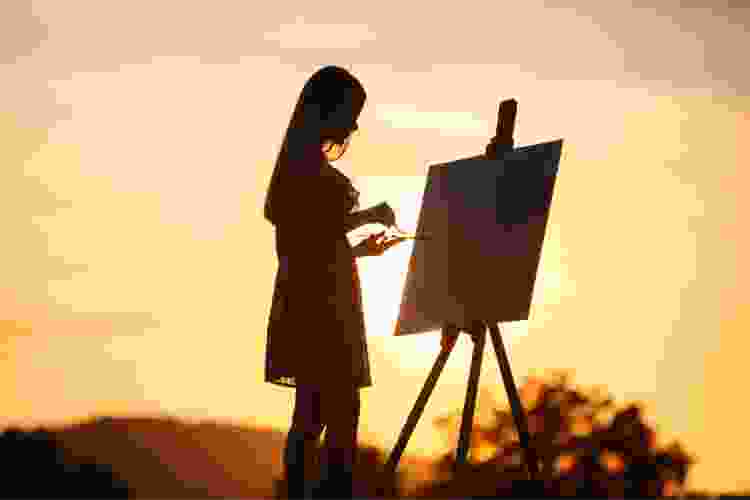 painter with easel in front of orange sunset