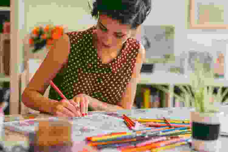 woman coloring in adult coloring book