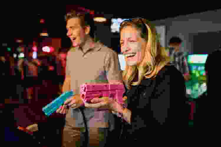 couple playing shooting games at adult arcade