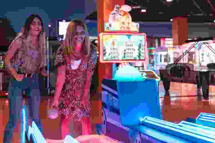 couple playing skeeball at the arcade