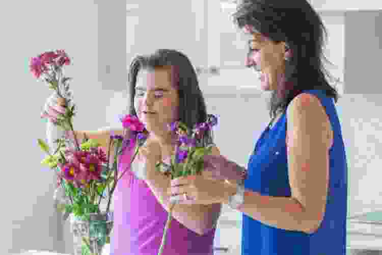 two women arranging flowers in the kitchen