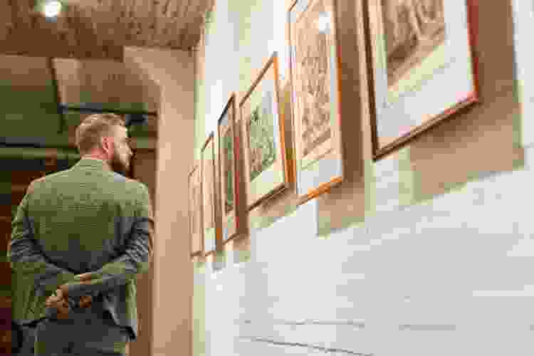 man perusing art gallery