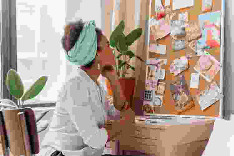 young woman admiring her cork memory board DIY gift idea