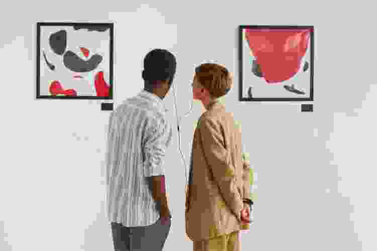 couple listening to music while looking at art in gallery