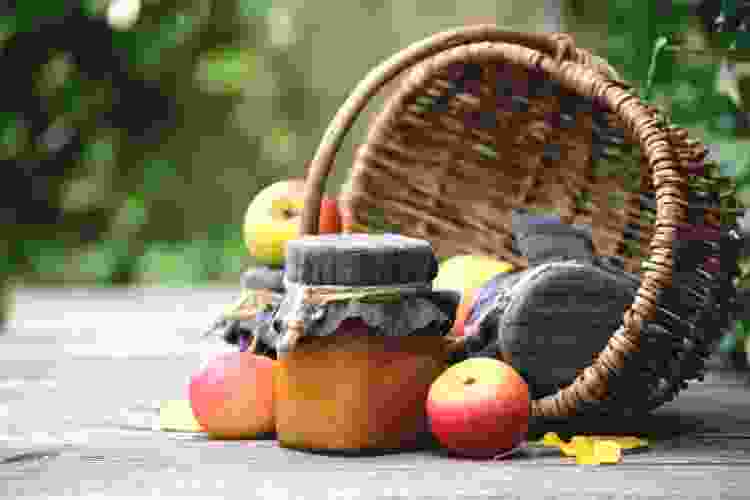 homemade jam in jar surrounded by fresh fruit