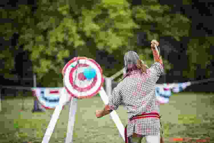 man throwing ax at wooden board