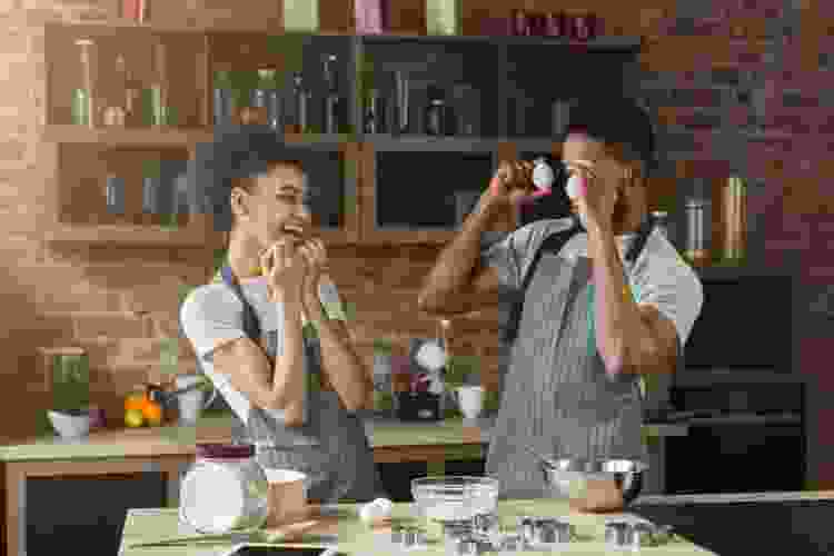 couple having fun with ingredients while baking cookies