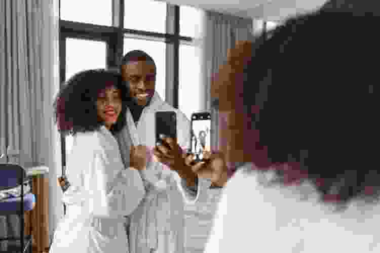 couple taking selfie in matching white bathrobes