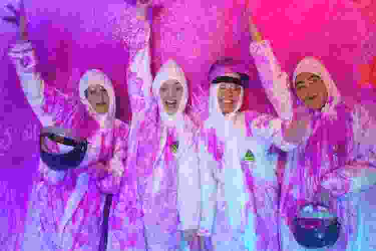 group of friends covered in bright pink paint