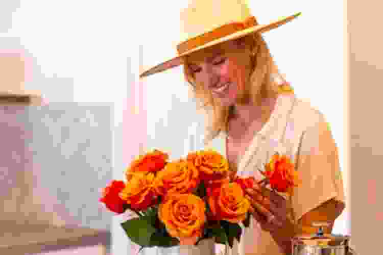 woman admiring bouquet of orange flowers