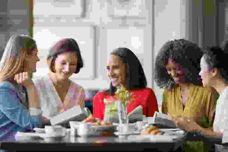 group of women meeting at café with books