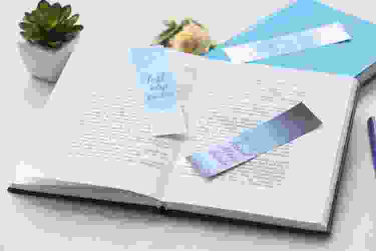 blue bookmarks with quotes sitting in open book