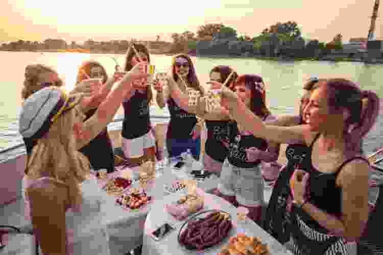 women cheersing drinks on a boat