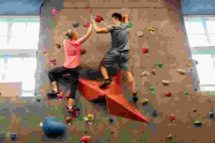 couple climbing in bouldering gym