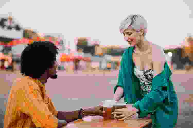 couple drinking beer at outdoor picnic table