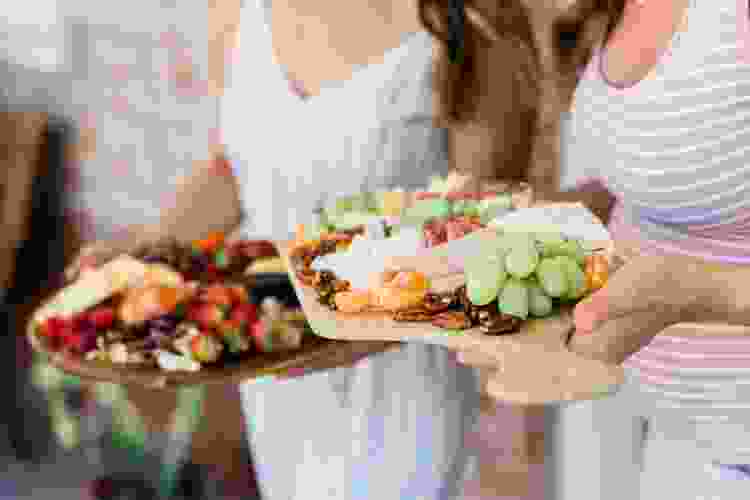 party guests carrying brunch charcuterie boards