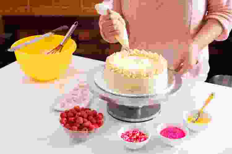 hand piping frosting on cake