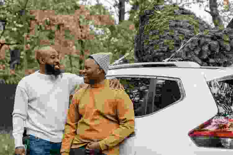 father and son standing by son's new car gift