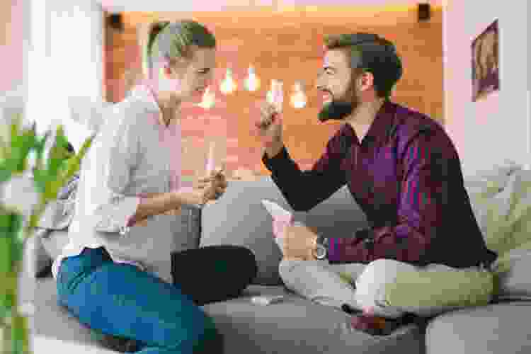 couple playing cards on the couch