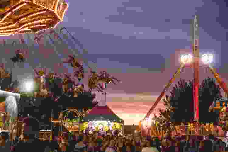 carnival rides lighting up at sunset